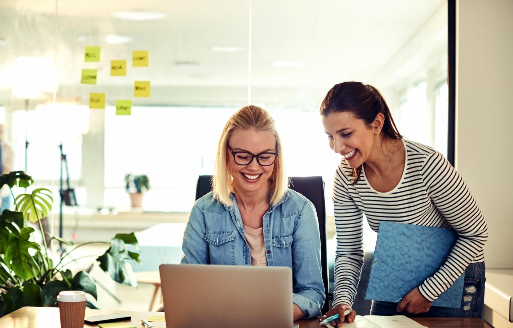 Students collaborating on financial analysis project with laptops and documents